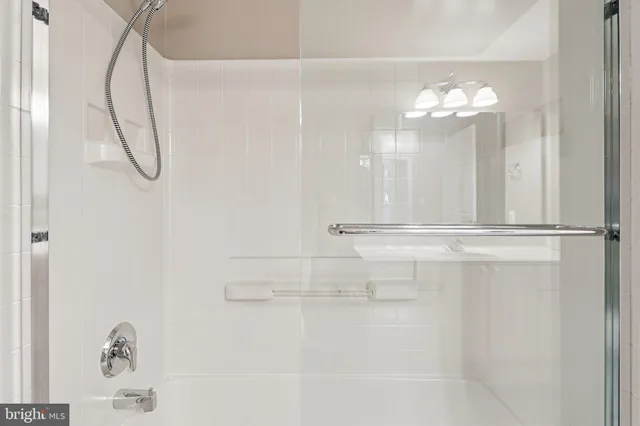 a bathroom with a tub shower sink and mirror