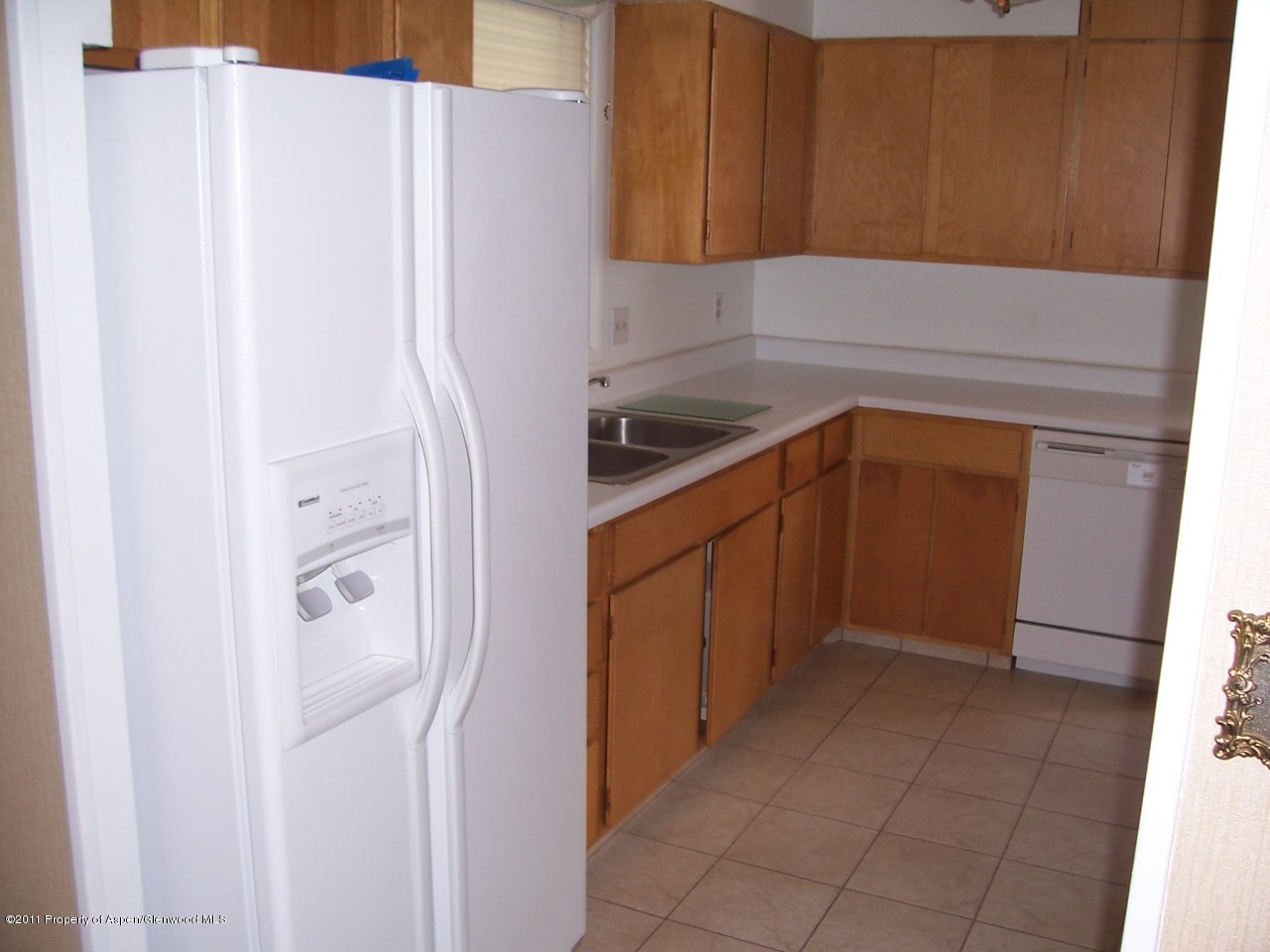703 West 3rd Street Rifle, CO 81650 - Photo 7 of 22 a kitchen with a refrigerator and cabinets