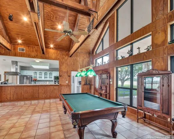 a room with pool table and windows