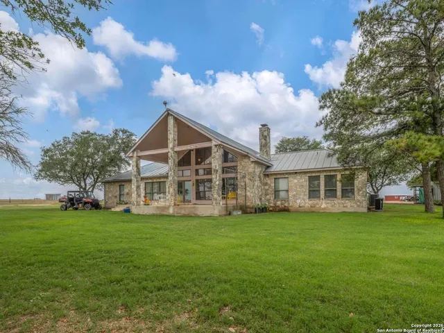 a view of a house with a big yard and large trees