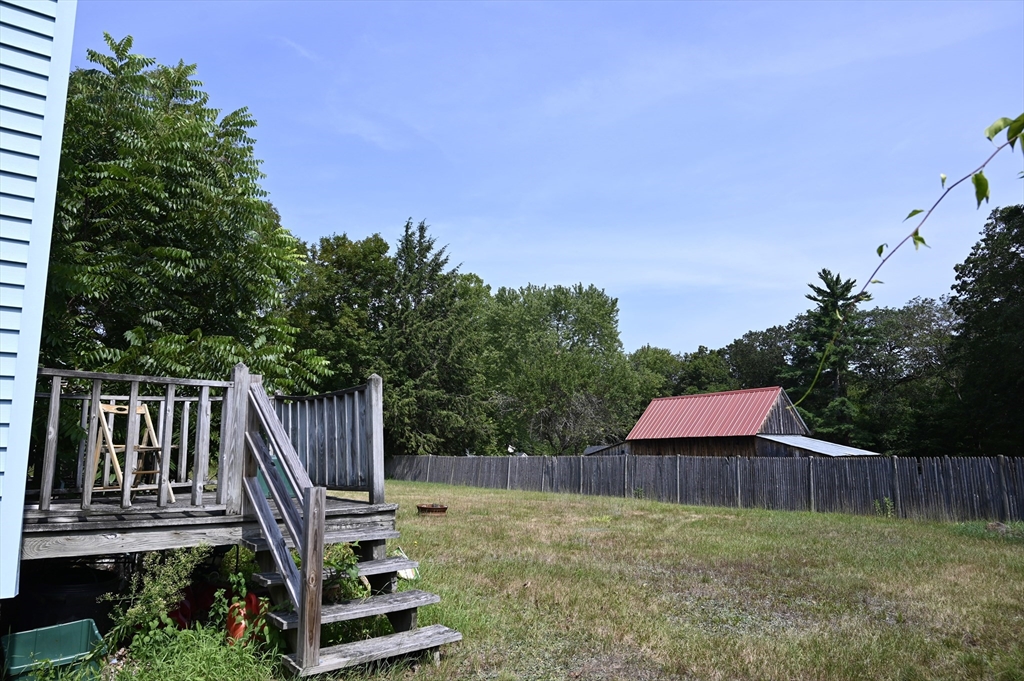 4 Spring Street Rochester, NH 03868 - Photo 12 of 29 a view of a backyard with plants and wooden fence