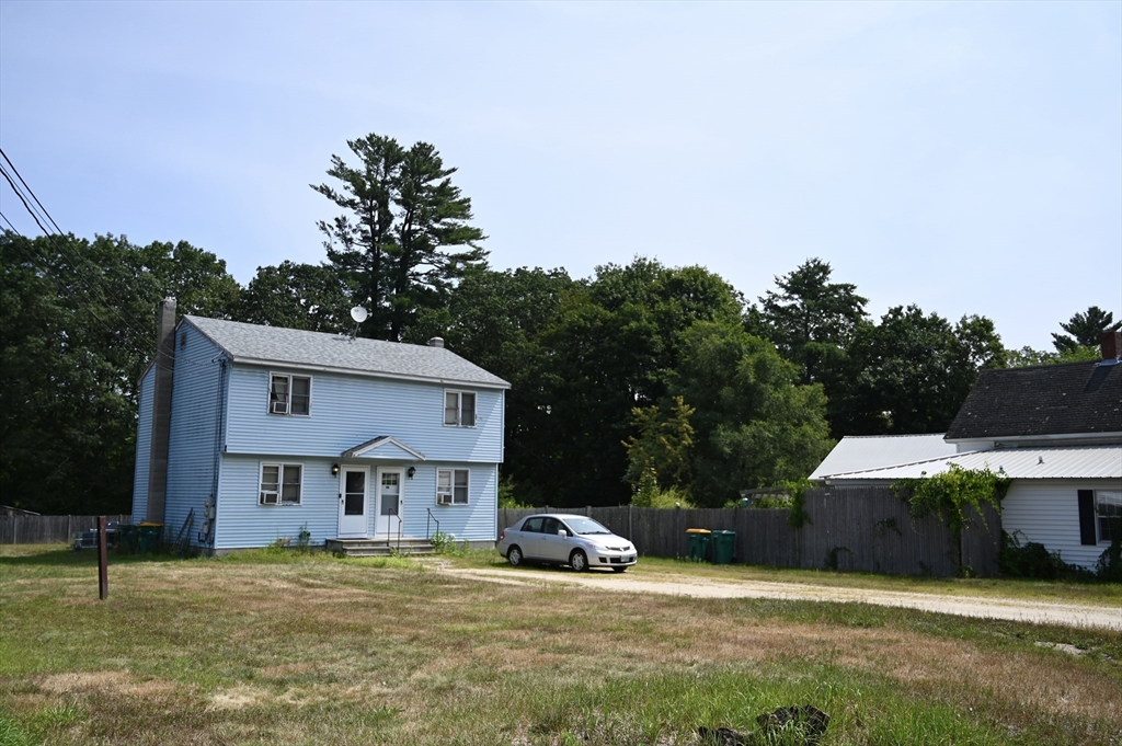 4 Spring Street Rochester, NH 03868 - Photo 3 of 29 a front view of house with yard and trees in the background