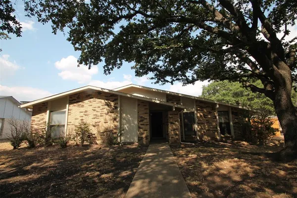 a front view of a house with a tree