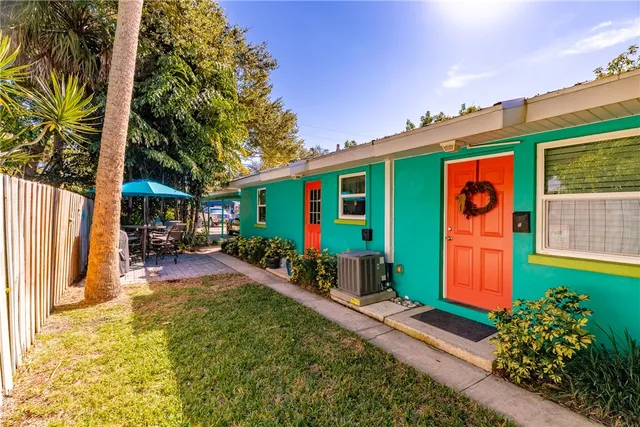 a view of a table and chairs in backyard under a umbrella