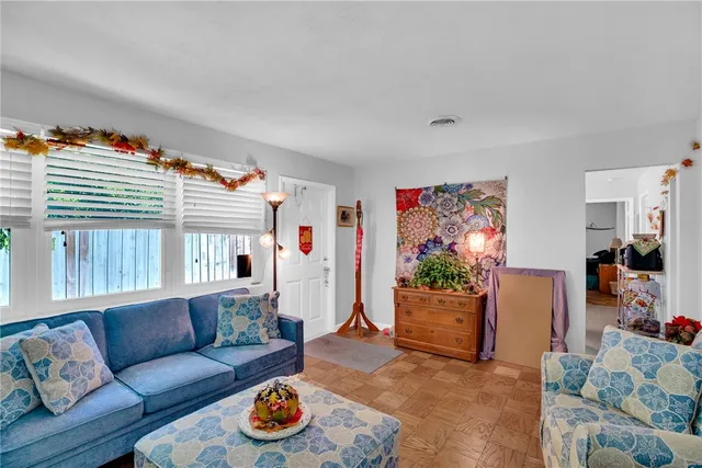 a large white kitchen with a stove a sink dishwasher and a dining table with wooden floor