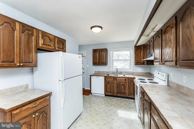 a kitchen with stainless steel appliances granite countertop a refrigerator stove top oven a sink and dishwasher