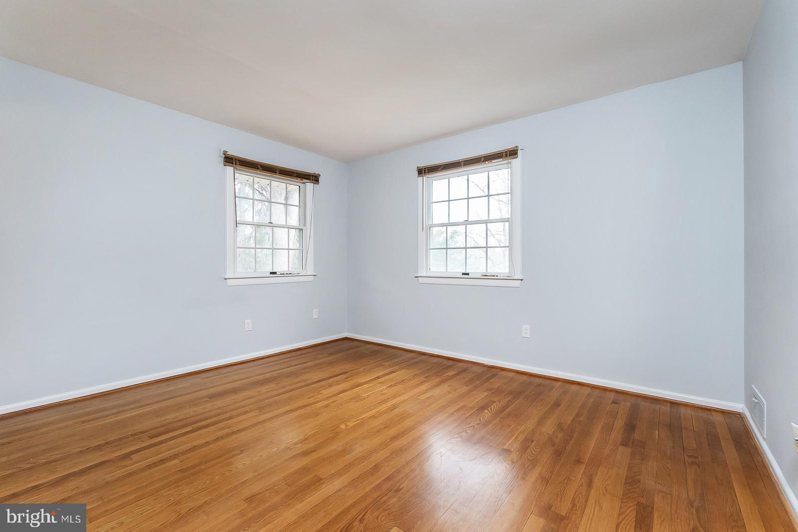 409 Orleans Circle Southwest Vienna, VA 22180 - Photo 10 of 23 an empty room with wooden floor and windows