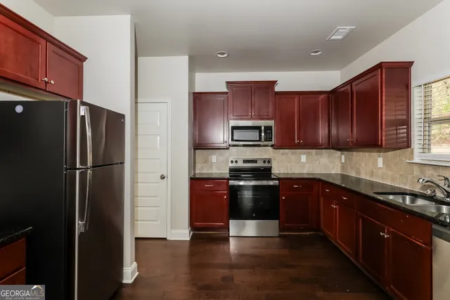 a kitchen with stainless steel appliances granite countertop a refrigerator stove and sink