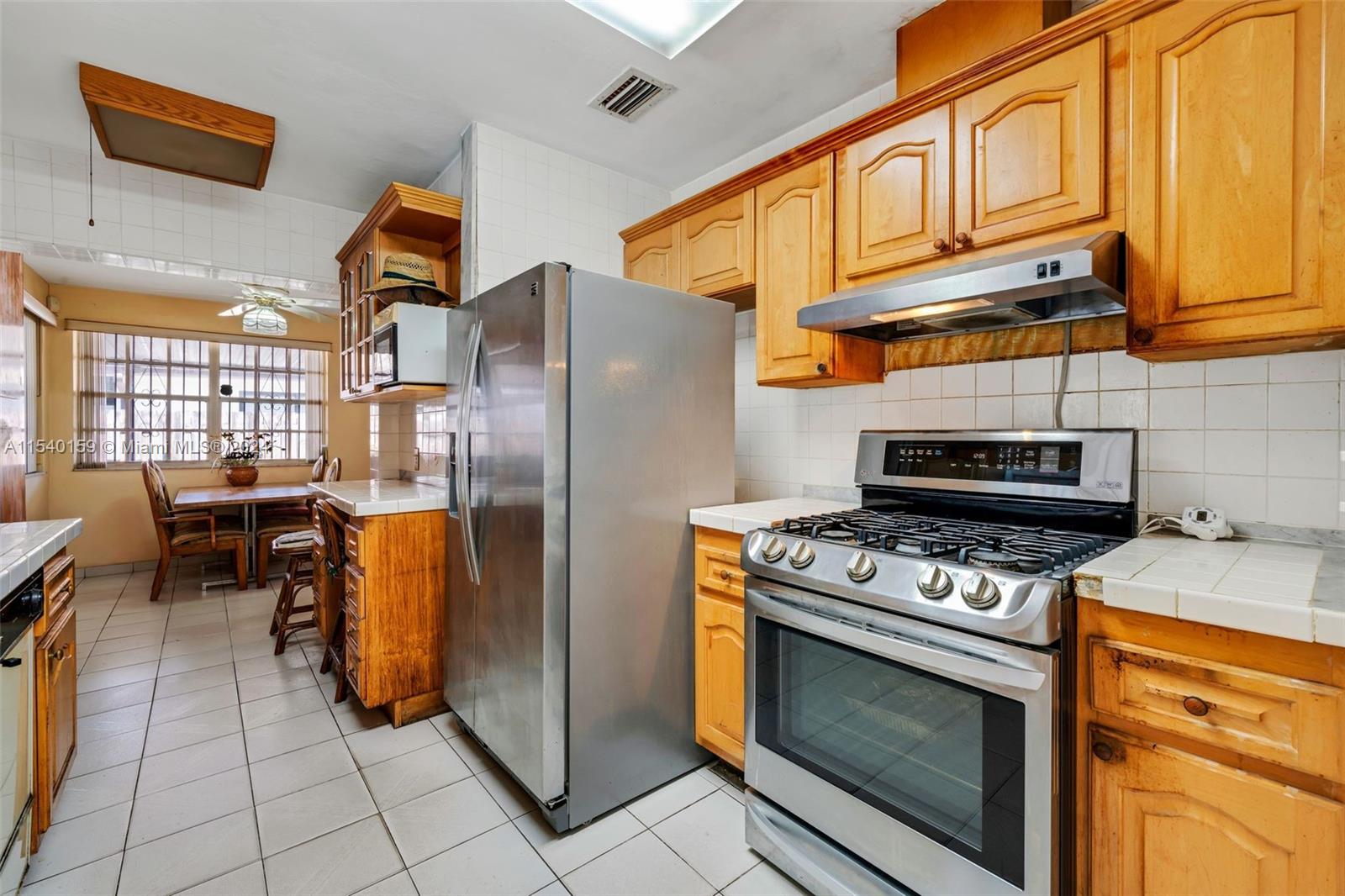 Westchester Miami, FL 33165 - Photo 19 of 30 a kitchen with stainless steel appliances granite countertop a stove a refrigerator and a cabinets