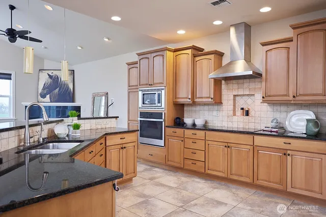 a kitchen with stainless steel appliances granite countertop a sink and cabinets