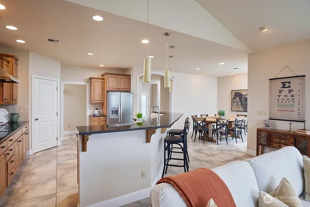 a living room with furniture kitchen view and a large window