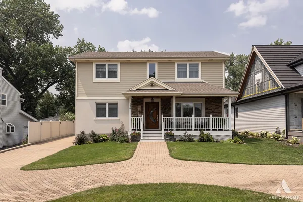 a front view of a house with a yard and potted plants