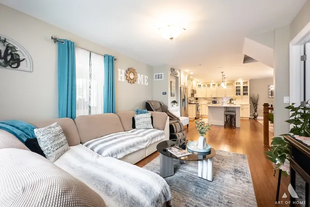 a view of a hallway with wooden floor and a bathroom