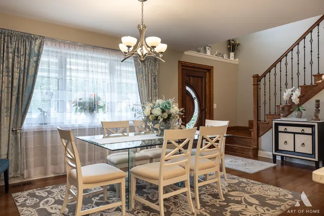 a dining room with wooden floor and chandelier
