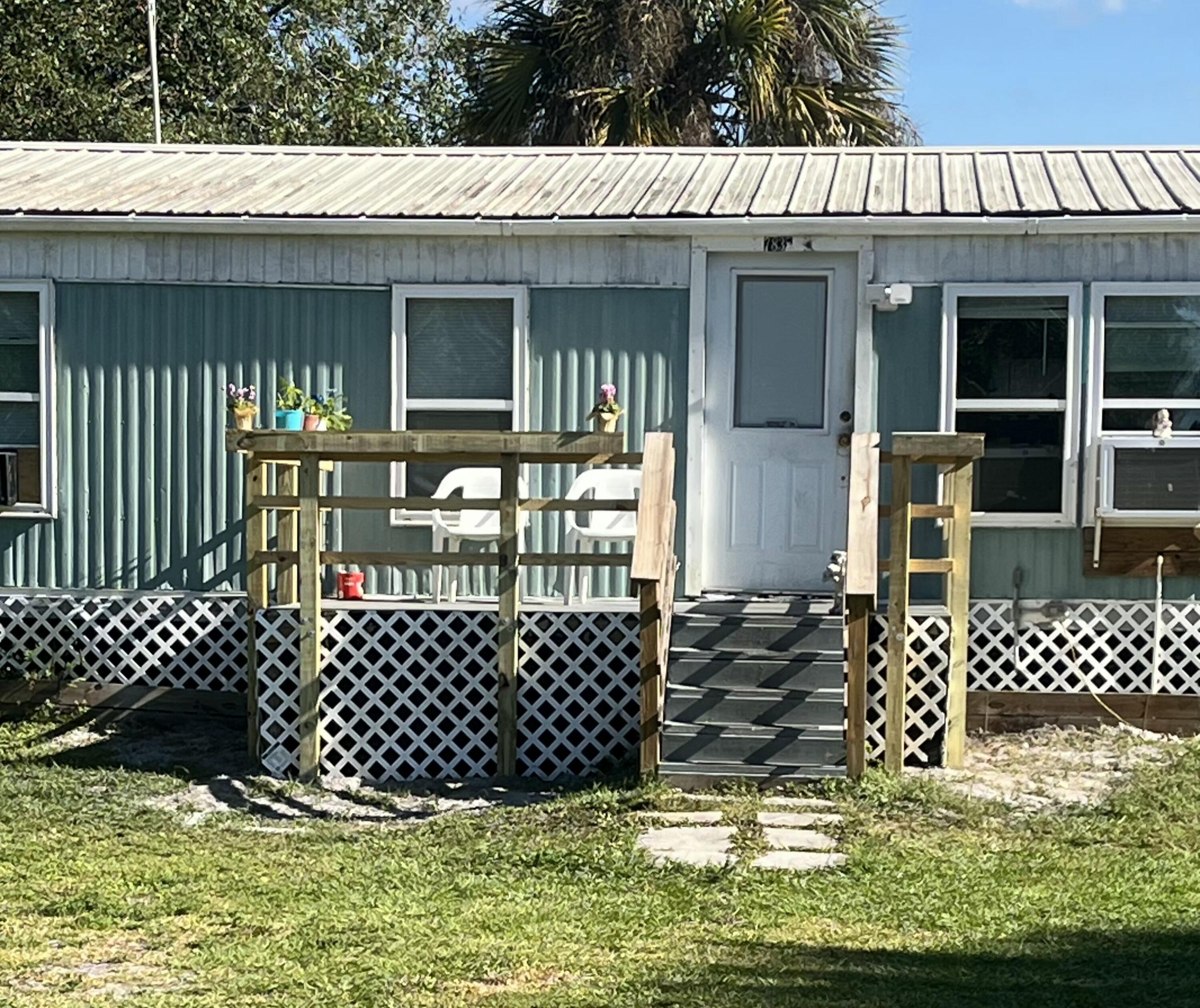 a view of a house with a small yard and wooden fence