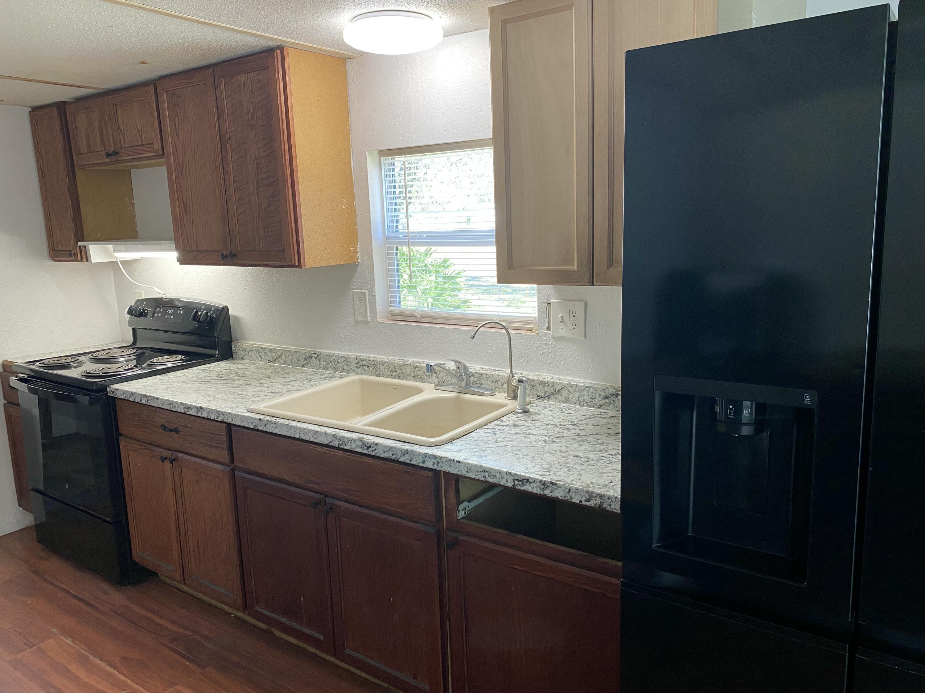 7835 Southeast 60th Drive Okeechobee, FL 34974 - Photo 12 of 35 a kitchen with a sink a window and cabinets