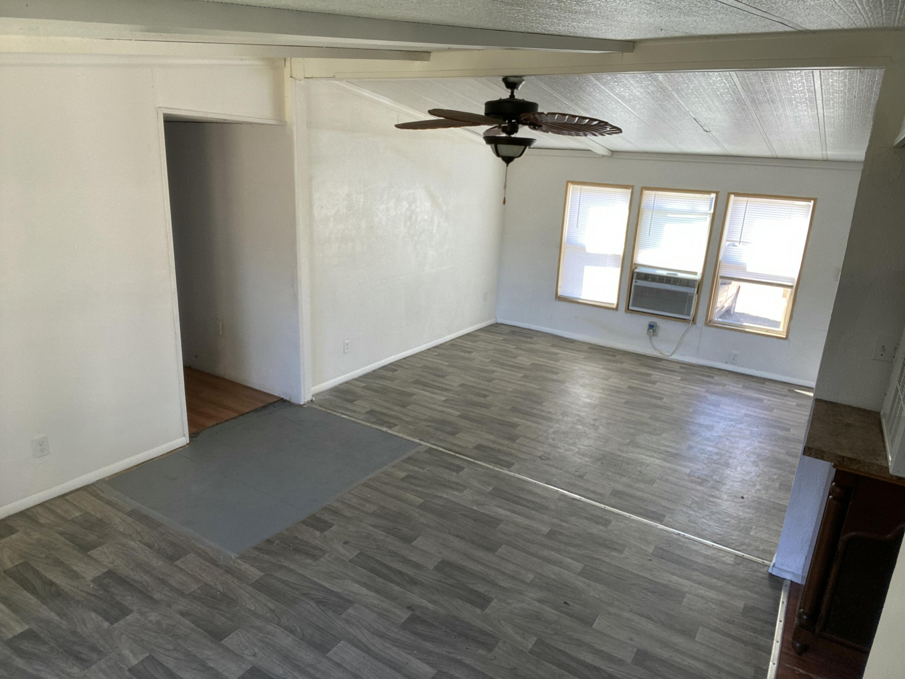 7835 Southeast 60th Drive Okeechobee, FL 34974 - Photo 3 of 35 a view of empty room with wooden floor and fan