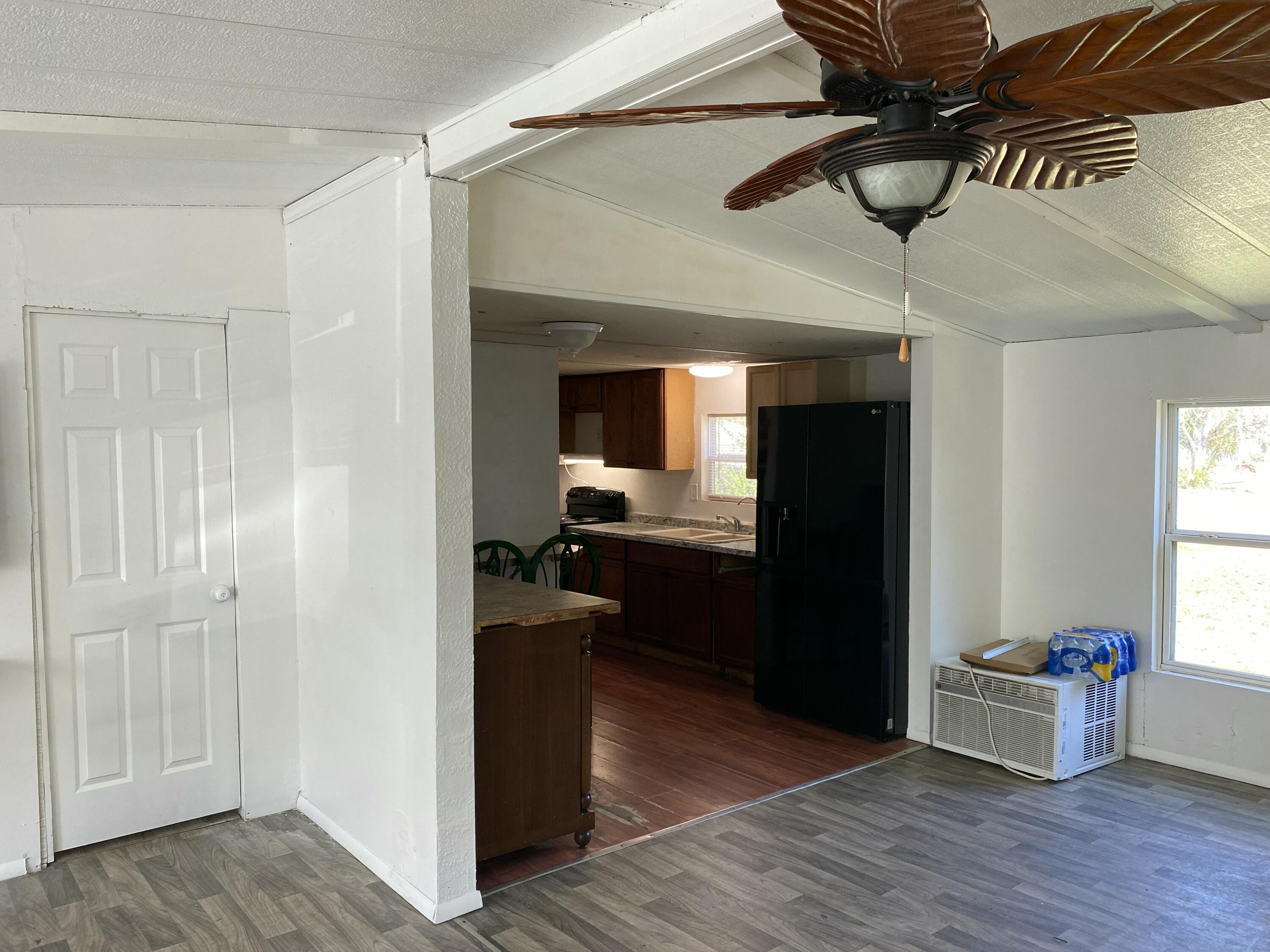 7835 Southeast 60th Drive Okeechobee, FL 34974 - Photo 8 of 35 a view of a hallway with wooden floor and cabinet