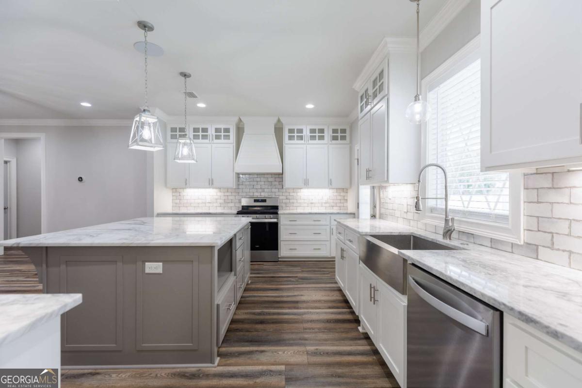 601 Pine Point Circle Valdosta, GA 31602 - Photo 13 of 45 a kitchen with stainless steel appliances granite countertop a sink a stove and a wooden floors