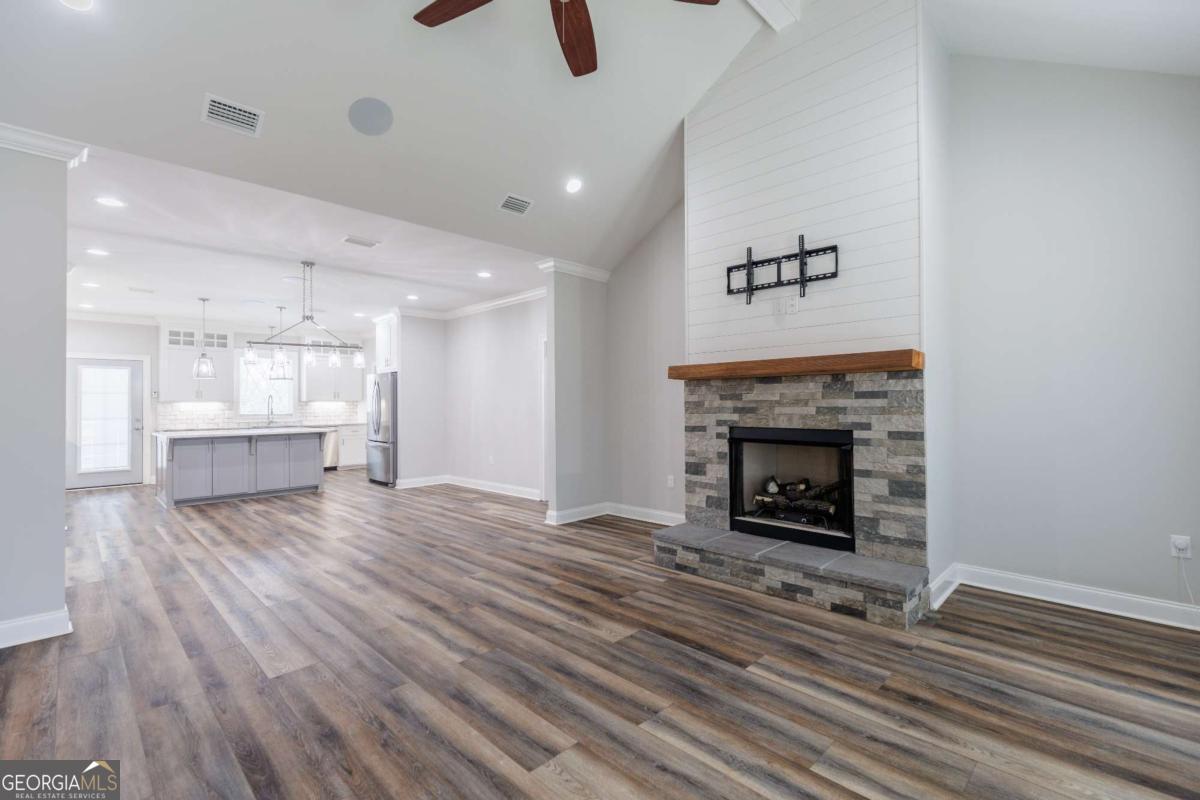601 Pine Point Circle Valdosta, GA 31602 - Photo 8 of 45 a view of an empty room with wooden floor fire place and windows