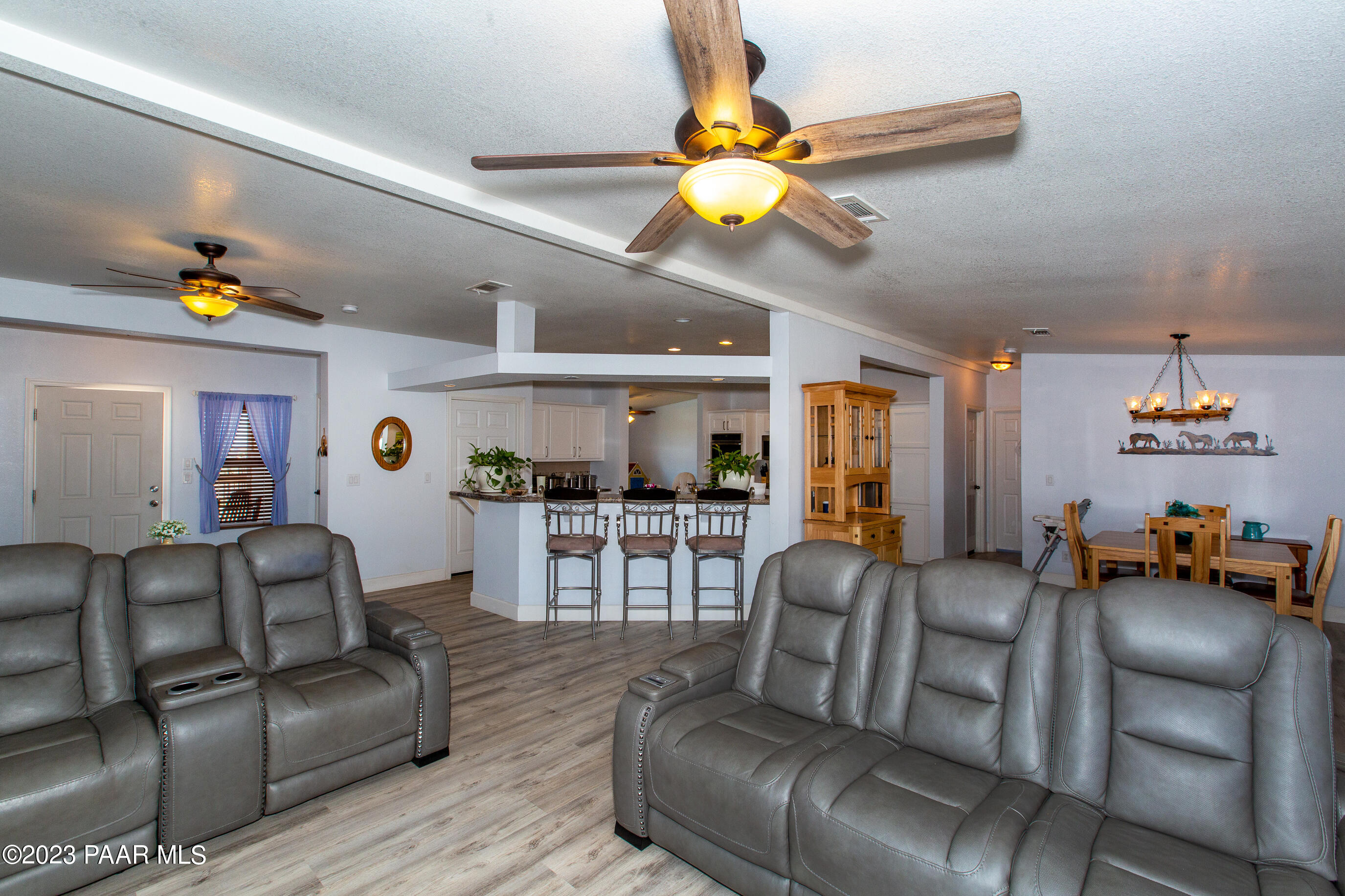 8855 East Turtle Rock Road Prescott Valley, AZ 86315 - Photo 12 of 62 a living room with furniture a chandelier and a dining table