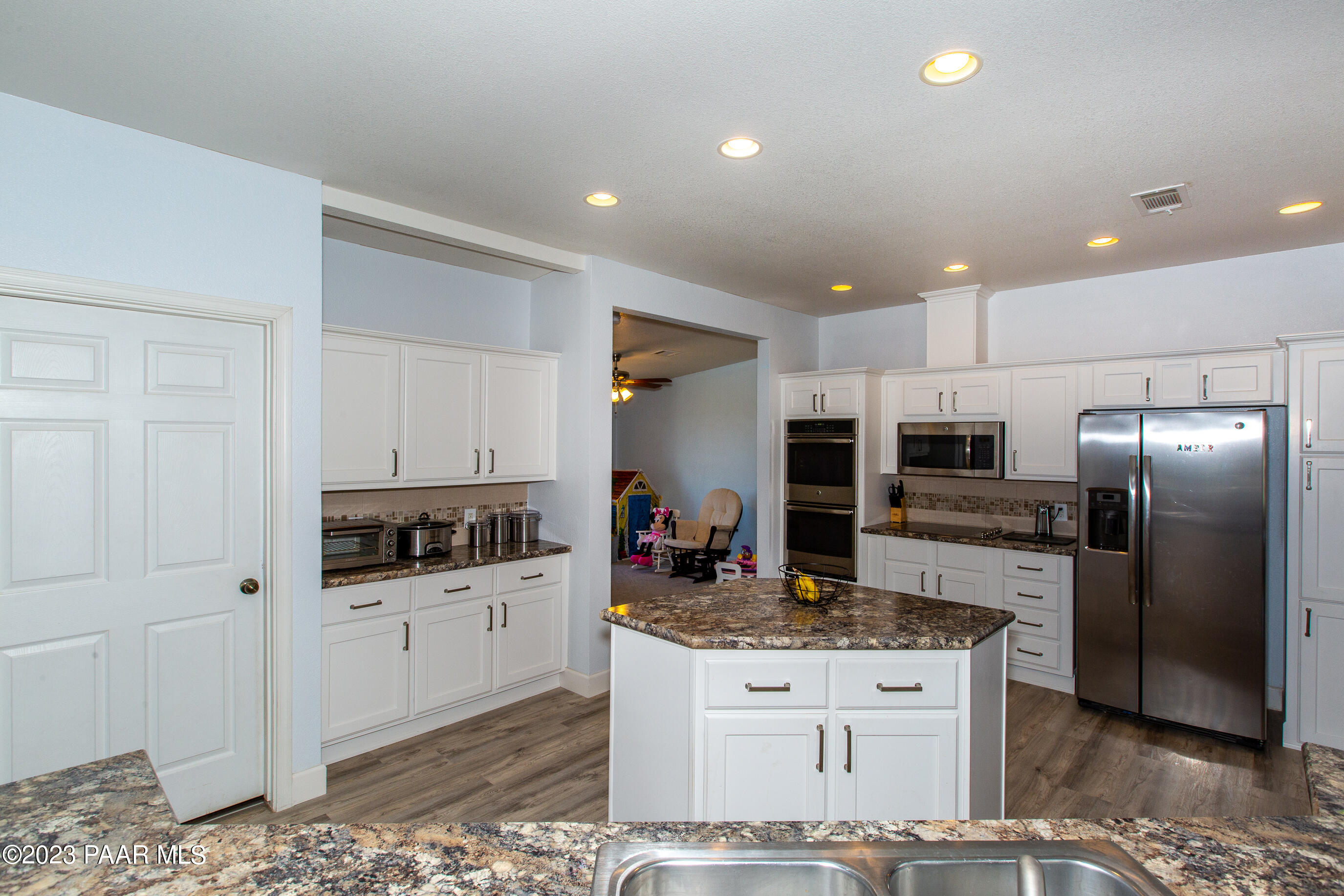 8855 East Turtle Rock Road Prescott Valley, AZ 86315 - Photo 14 of 62 a kitchen with stainless steel appliances kitchen island granite countertop a stove top oven a sink and a refrigerator