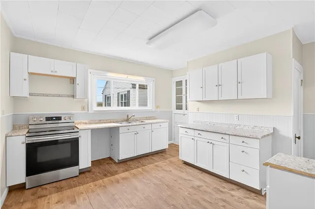 a kitchen with granite countertop white cabinets and stainless steel appliances