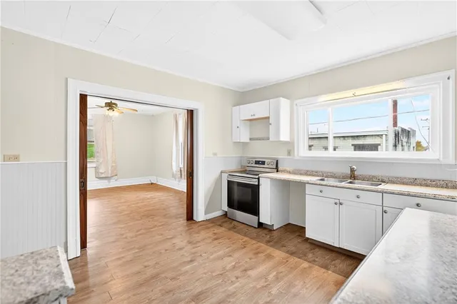 a view of a kitchen with a sink cabinets and wooden floor