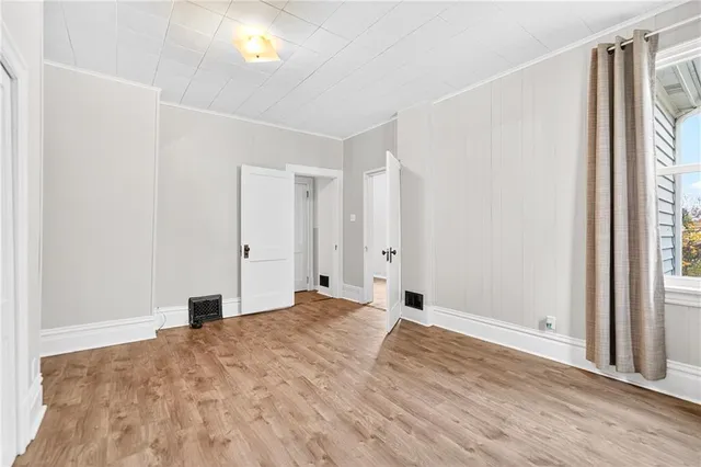 a view of a room with wooden floor and window