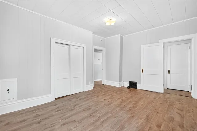 a view of empty room with wooden floor