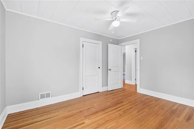 a view of a room with wooden floor and a ceiling fan