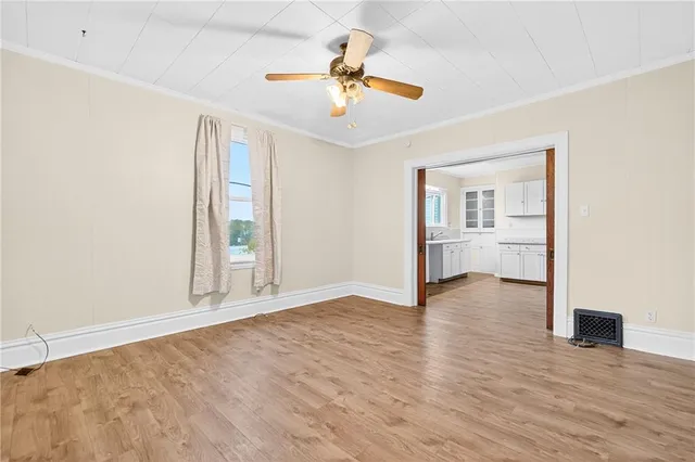 a view of an empty room and window with wooden floor