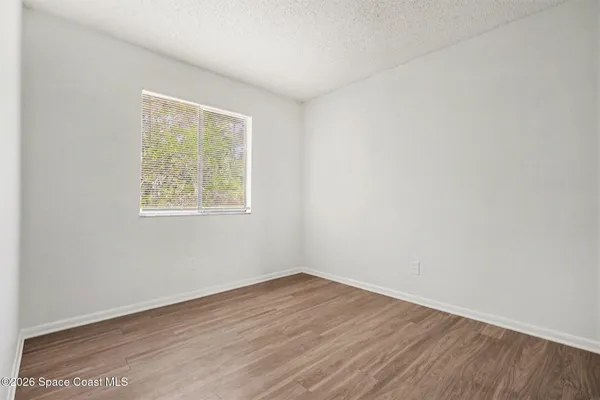 an empty room with wooden floor and a window