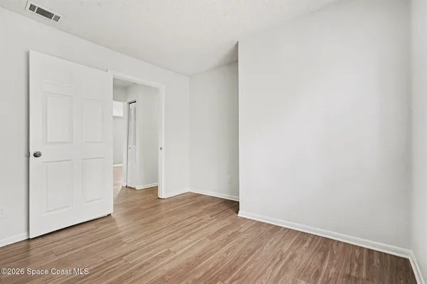 a view of an empty room with wooden floor
