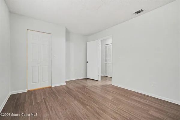 a view of an empty room with wooden floor