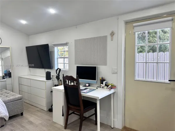 a view of a workspace with furniture and a window