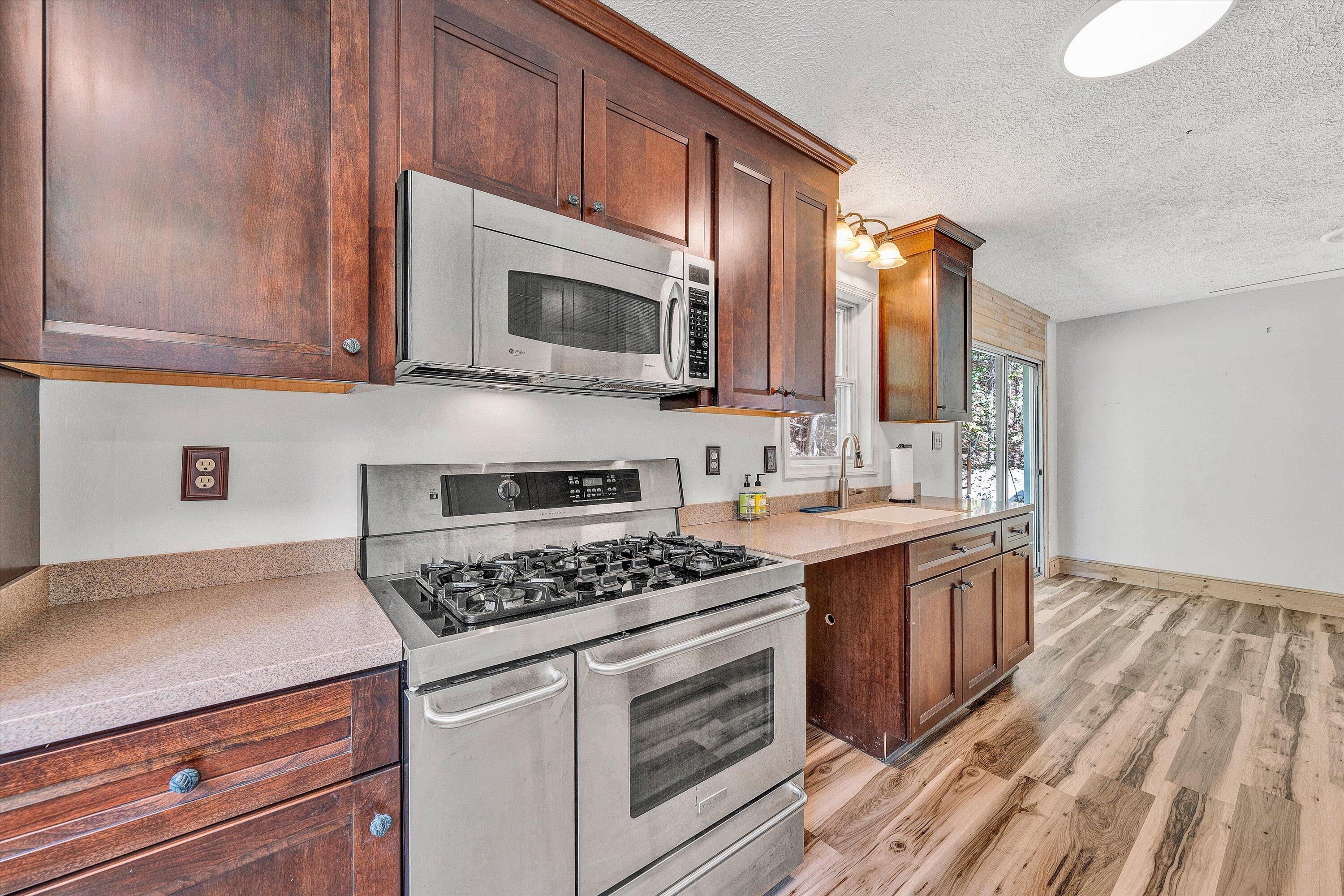 3561 Rutrough Road Southeast Roanoke, VA 24014 - Photo 28 of 63 a kitchen with stainless steel appliances granite countertop a stove a sink and a microwave