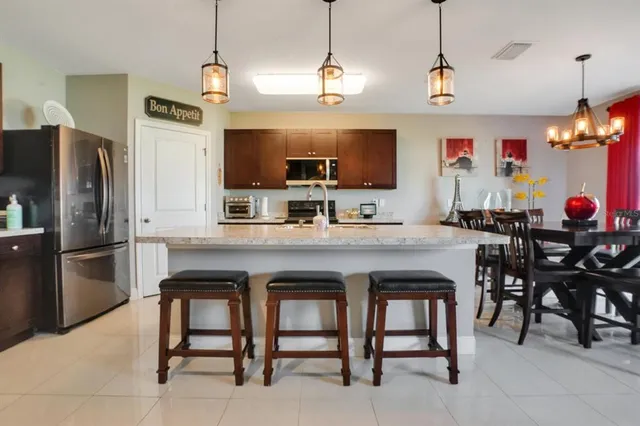 a kitchen with stainless steel appliances granite countertop a sink a stove a refrigerator and a refrigerator