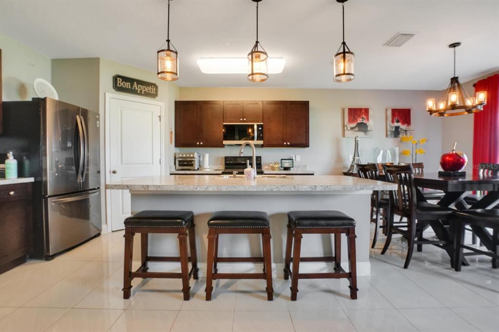 4583 Northeast 27th Street Ocala, FL 34470 - Photo 11 of 43 a kitchen with stainless steel appliances granite countertop a sink a stove a refrigerator and a refrigerator
