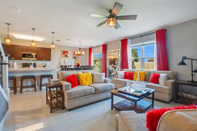 a living room with furniture kitchen view and a large window