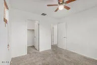 a view of an empty room and chandelier fan