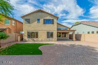 a front view of a house with a yard and potted plants