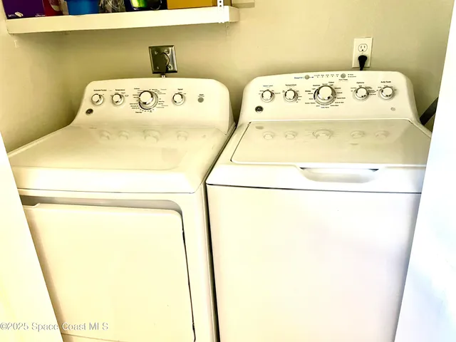 a view of a kitchen with kitchen island granite countertop a sink and a refrigerator