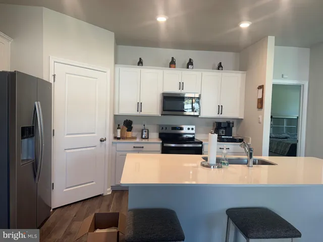 a kitchen with a dining table chairs and white cabinets