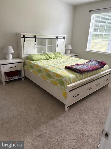 a bed sitting in a bedroom next to a window