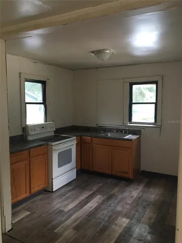 a kitchen with granite countertop white cabinets and white appliances