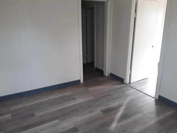 a view of an empty room with wooden floor