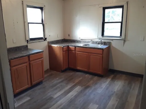 a kitchen with granite countertop wooden floors and sink