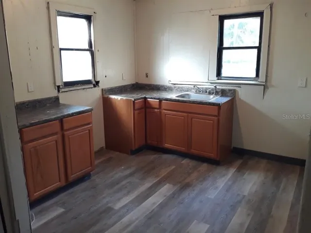 a kitchen with granite countertop wooden floors and sink
