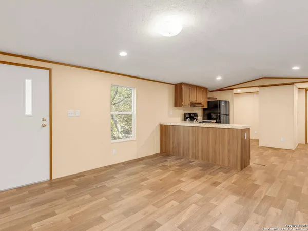 a view of kitchen with kitchen island stainless steel appliances a sink and a refrigerator